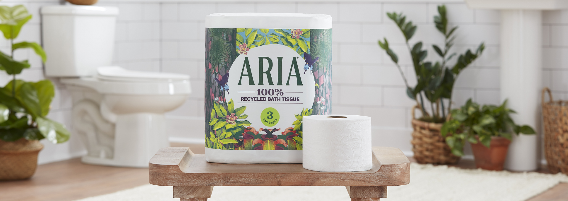 A package of 100% recycled Aria bath tissue sitting on top of a wooden stand.