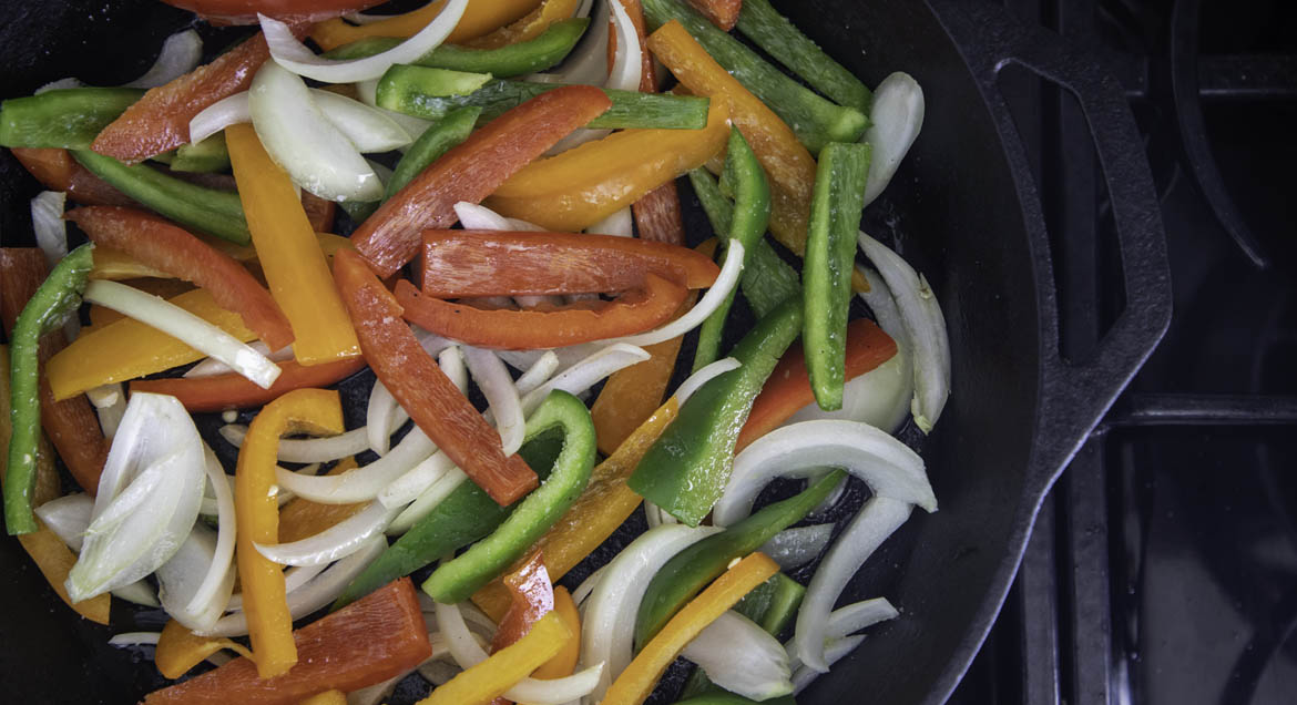 Chopped Peppers And Onions Sizzle In Pan For Tofu Sofrita Tacos.