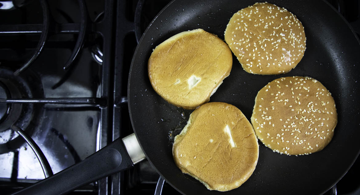 Hamburger Buns Being Toasted In Frying Pan.