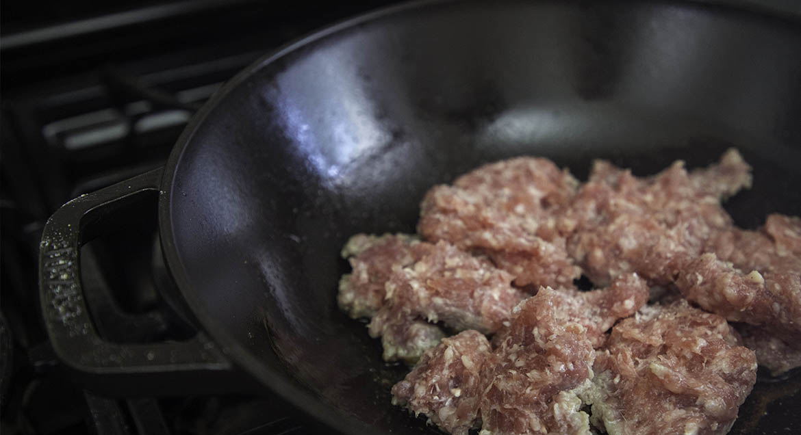 Ground Beef Cooking In Cast Iron Wok.
